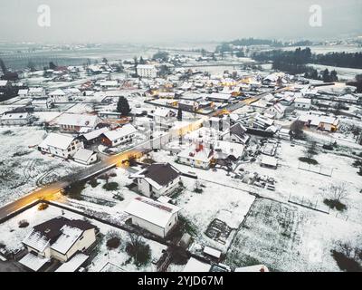 Vista aerea della comunità suburbana in inverno la sera. Neve sul terreno, buio, luci stradali brillanti Foto Stock