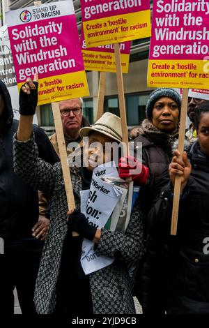 Londra, Regno Unito. 28 aprile 2018. Una donna alla protesta al di fuori del Ministero degli interni indica il messaggio sul suo cartello "solidarietà con la generazione Windrush”. La protesta è stata convocata da un individuo disgustato dall'incompetenza del governo e deliberatamente ha preso di mira gli immigrati legali. L'organizzatrice Sara Burke ha scritto che "il trattamento ripugnante del governo nei confronti di coloro che provengono dalla generazione Windrush è un imbarazzo nazionale" e ha pianificato la marcia verso l'Home Office per fare pressione su di loro affinché mantengano le promesse fatte a queste persone. Oltre all'organizzatrice dell'evento Sara Burke, c'erano anche relatori Foto Stock