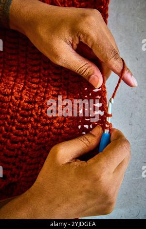 Mani afroamericane che uniscono Rust Yarn Close-Up Motion Foto Stock