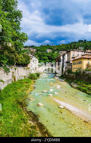 ROVERETO, ITALIA – 21 AGOSTO 2024: Il fiume Adige scorre tranquillamente attraverso la città di Rovereto, con le sue pittoresche sponde immerse nel verde, offrono Foto Stock