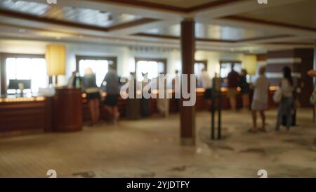 Persone sfocate in piedi in una lussuosa sala delle navi da crociera, con un elegante effetto bokeh interno che enfatizza un ambiente sontuoso e un'atmosfera di svago. Foto Stock