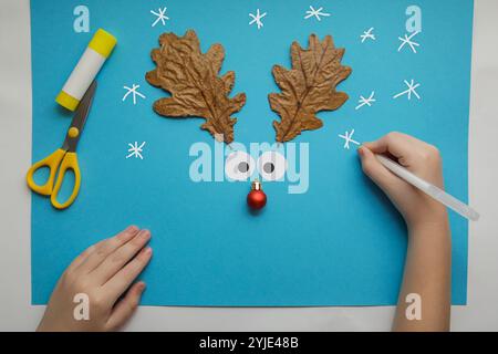 Artigianato invernale per bambini con materiali naturali e carta. decorazione renna. Progetto d'arte per bambini. Concetto fai da te. Artigianato di carta facile e artigianale per bambini Foto Stock