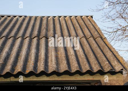 Vecchi tetti in ardesia di amianto. Rilascio di amianto da edifici con tetto in ardesia in cemento-amianto Foto Stock