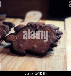 Pane di zenzero marrone appena sfornato su un piatto di legno. Dolce mandorla svedese sottile per festeggiare il Natale. Foto Stock