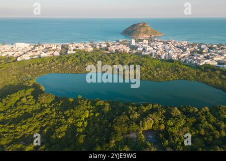 Vista aerea di un lago in un parco e case di fronte alla spiaggia con Pontal Rock nell'Oceano a Rio de Janeiro Foto Stock