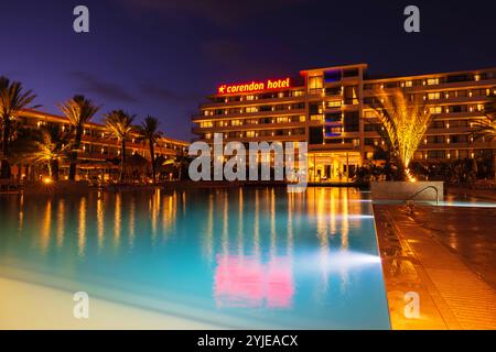 Vista notturna del Corendon Hotel a Curacao con luci accese, palme e riflessi della piscina che creano un'atmosfera serena. Curacao. Willemstad. Foto Stock