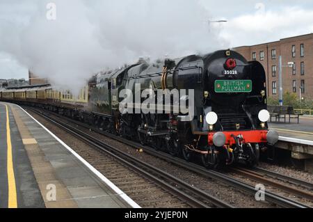 Locomotiva a vapore British Pullman con la Remembrance Sunday e la corona di papavero dell'Armistizio Day sotto la cisterna di smokestack passando per la stazione di Rochester nel Kent Foto Stock