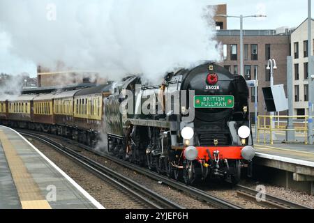 Locomotiva a vapore British Pullman con la Remembrance Sunday e la corona di papavero dell'Armistizio Day sotto la cisterna di smokestack passando per la stazione di Rochester nel Kent Foto Stock