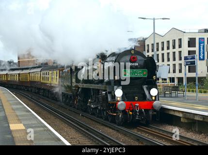 Locomotiva a vapore British Pullman con la Remembrance Sunday e la corona di papavero dell'Armistizio Day sotto la cisterna di smokestack passando per la stazione di Rochester nel Kent Foto Stock