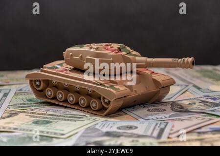 Due carri armati militari, dollari americani, primo piano. Concetto: Spesa per le armi, aiuti militari, commercio di armi Foto Stock