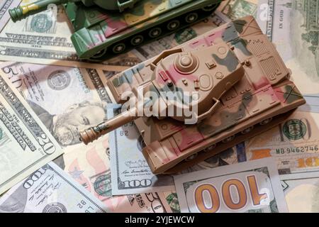 Due carri armati militari, dollari americani, primo piano. Concetto: Spesa per le armi, aiuti militari, commercio di armi Foto Stock