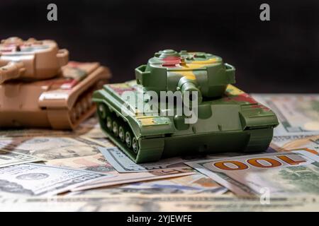 Due carri armati militari, dollari americani, primo piano. Concetto: Spesa per le armi, aiuti militari, commercio di armi Foto Stock