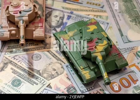 Due carri armati militari, dollari americani, primo piano. Concetto: Spesa per le armi, aiuti militari, commercio di armi Foto Stock