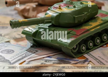 Due carri armati militari, dollari americani, primo piano. Concetto: Spesa per le armi, aiuti militari, commercio di armi Foto Stock