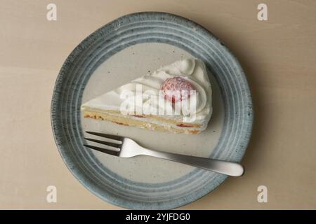 Shortcake e forchetta di fragole giapponesi su ogni piatto grande e piccolo su un tavolo di legno. Foto Stock