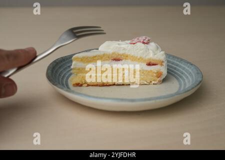Shortcake e forchetta di fragole giapponesi su ogni piatto grande e piccolo su un tavolo di legno. Foto Stock