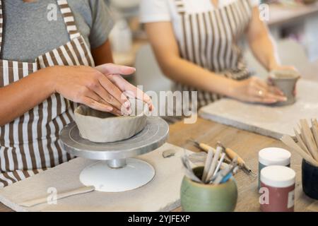 Due giovani lavoratrici di ceramica scolpite dall'argilla cruda Foto Stock