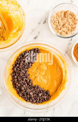 Impasto per muffin di zucca con gocce di cioccolato pronto per essere mescolato Foto Stock