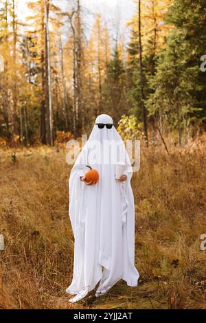Persona in piedi in costume fantasma con zucca e caffè e. Foto Stock
