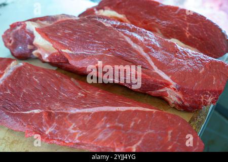 Tre pezzi di carne sono su un tagliere Foto Stock