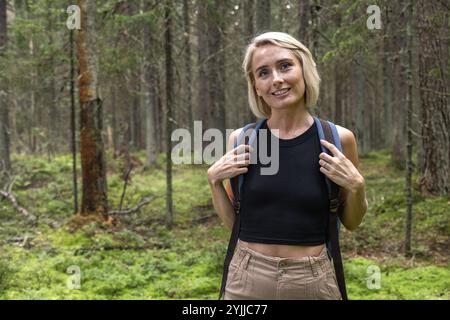 Donna bionda ritratta con zaino per escursioni nella foresta Foto Stock