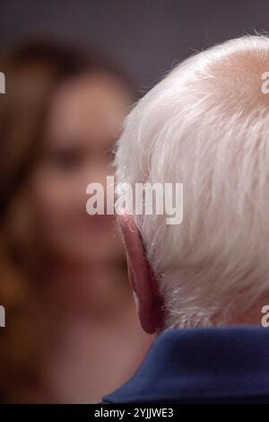 vista posteriore dell'uomo dai capelli grigi più anziano di fronte all'immagine sfocata della donna più giovane Foto Stock