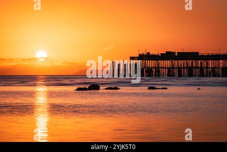 Tramonto con la bassa marea sul lungomare di Hastings, nell'est del Sussex, nell'Inghilterra sud-orientale, Regno Unito Foto Stock