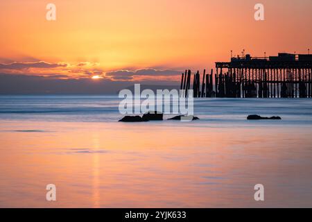 Tramonto con la bassa marea sul lungomare di Hastings, nell'est del Sussex, nell'Inghilterra sud-orientale, Regno Unito Foto Stock