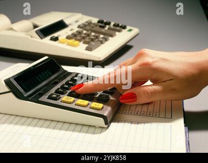 Affari. Primo piano della mano della donna usando la calcolatrice. Foto Stock