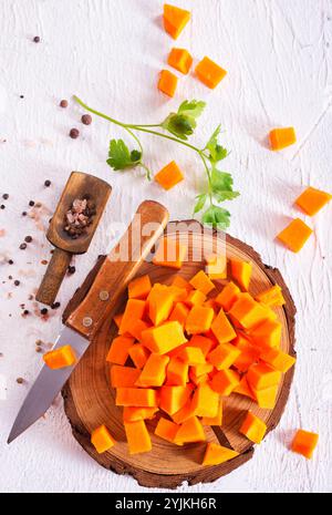 cubetti di zucca crudi su tavola di legno Foto Stock