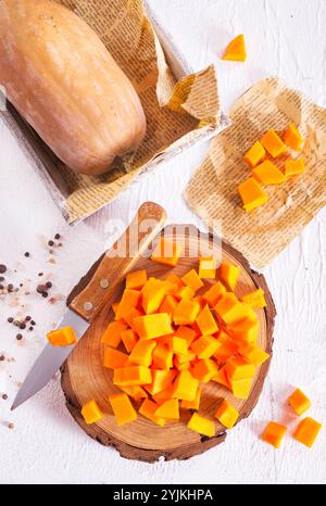cubetti di zucca crudi su tavola di legno Foto Stock