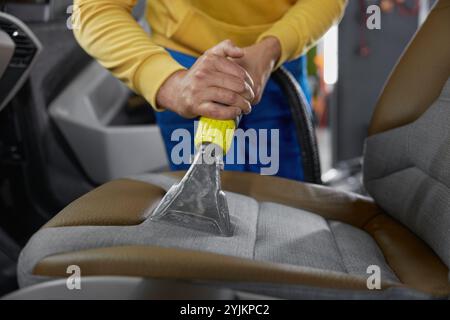 Pulizia degli interni dell'auto con l'aspirapolvere Foto Stock