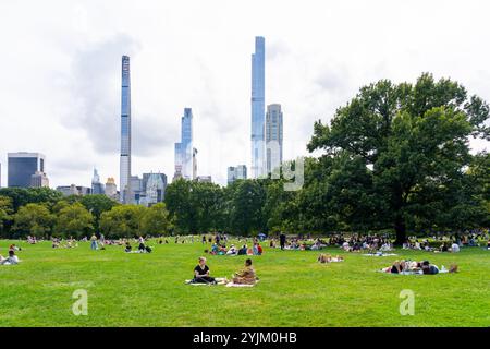 Persone sedute sull'erba al Central Park di New York, New York, USA Foto Stock