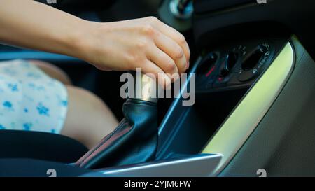 Primo piano irriconoscibile donna caucasica ragazza acquirente di auto autista di auto cambio manuale femmina cambio marce cambio manuale controllo della leva del cambio Foto Stock