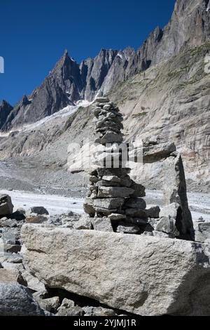 Il torrente glaciale sul ghiacciaio Mer de Glace con le torri di Aigulles sullo sfondo. Foto Stock