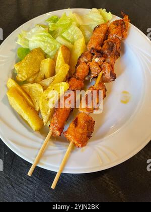 Brochette di pollo con patatine e lattuga. Foto Stock