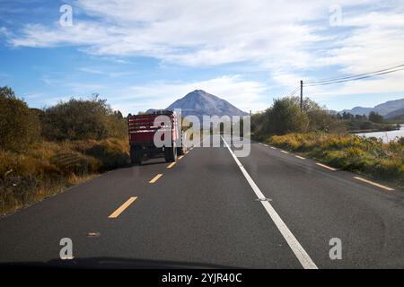 trattore che percorre il lato della strada per consentire all'auto di passare sulla n56 gweedore verso errigal, contea di donegal, repubblica d'irlanda Foto Stock