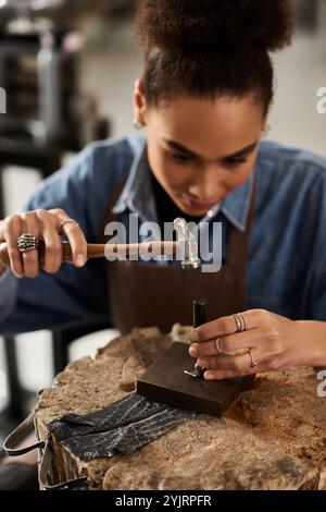 Un'artigiana di talento si concentra sul suo mestiere, dando forma a splendidi gioielli con cura e precisione. Foto Stock