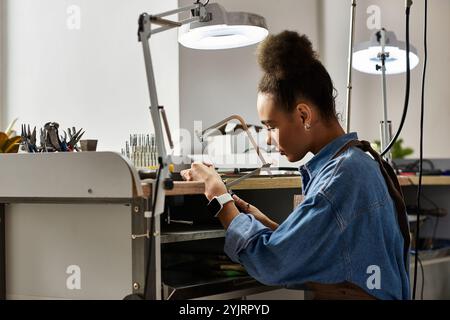 Un artigiano di talento si concentra sulla creazione di splendidi gioielli all'interno di uno spazio di lavoro ben attrezzato. Foto Stock