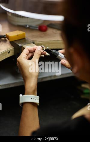 Una donna di talento si concentra sulla creazione di splendidi gioielli con dettagli intricati. Foto Stock