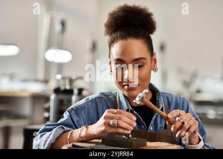 Una donna di talento modella con cura il metallo, mostrando la sua arte e la sua passione per il design dei gioielli. Foto Stock