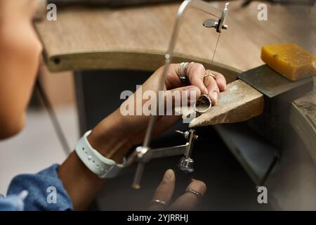 Una donna di talento si concentra sulla creazione di un anello bellissimo, mostrando la sua esperienza con i gioielli. Foto Stock