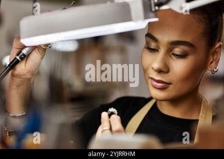 Una donna di talento sta lavorando con cura su una preziosa pietra preziosa, mostrando la sua arte e la sua attenzione. Foto Stock