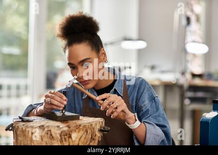 Una donna di talento si concentra sulla progettazione di gioielli squisiti nel suo spazio di lavoro creativo. Foto Stock