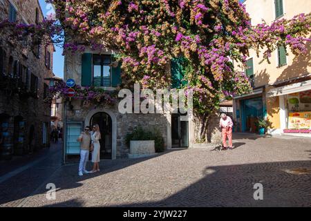 SIRMIONE, ITALIA - 22 OTTOBRE 2024: Bellissime bouganville che coprono un caffè a Sirmione, Lago di Garda, Italia Foto Stock