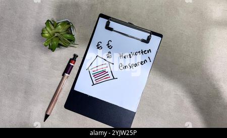 Concetto di Heizkosten Einsparen sulla lingua tedesca scrivere su documenti isolati su un tavolo di legno. Tedesco significa risparmiare sui costi di riscaldamento Foto Stock