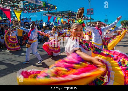 Una donna colombiana, che gira una tradizionale gonna cumbia, balla la cumbia durante la Batalla de Flores, la principale parata del Carnevale a Barranquilla, Colombia. Foto Stock