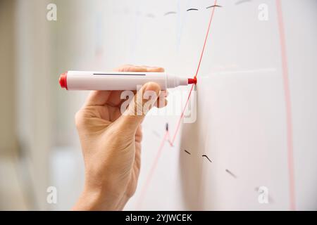 L'uomo sta disegnando un grafico su una lavagna Foto Stock