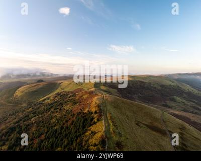 Splendida vista aerea di un colorato paesaggio autunnale con nuvole basse, nebbia e sole al tramonto Foto Stock