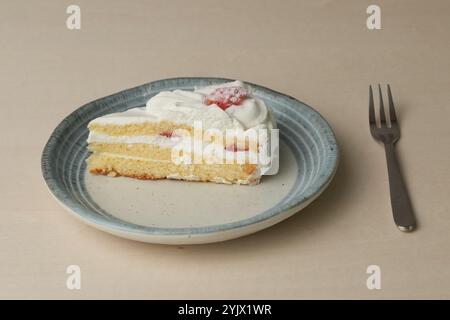 Shortcake e forchetta di fragole giapponesi su ogni piatto grande e piccolo su un tavolo di legno. Foto Stock